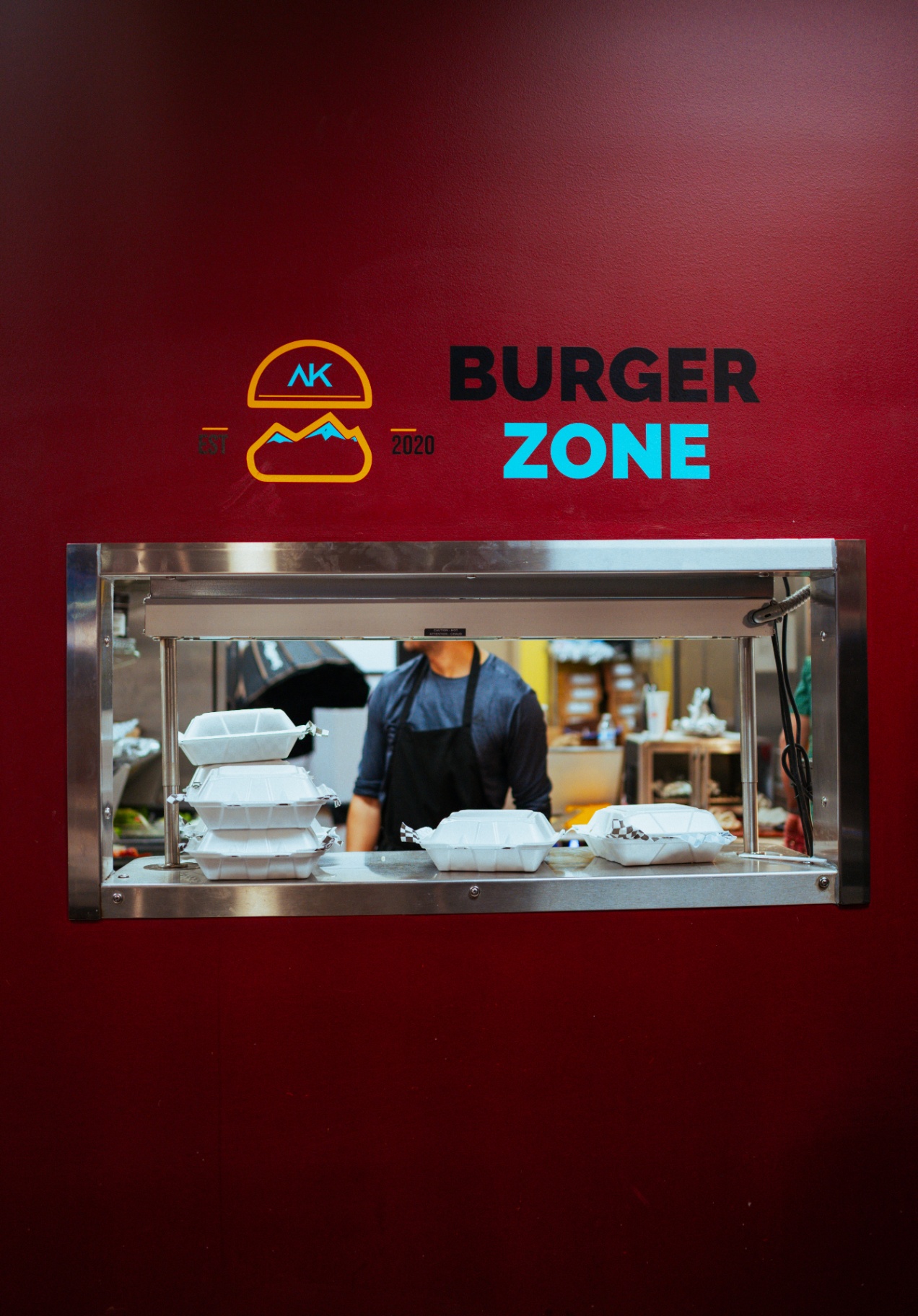 Kitchen pickup window with Burger Zone logo